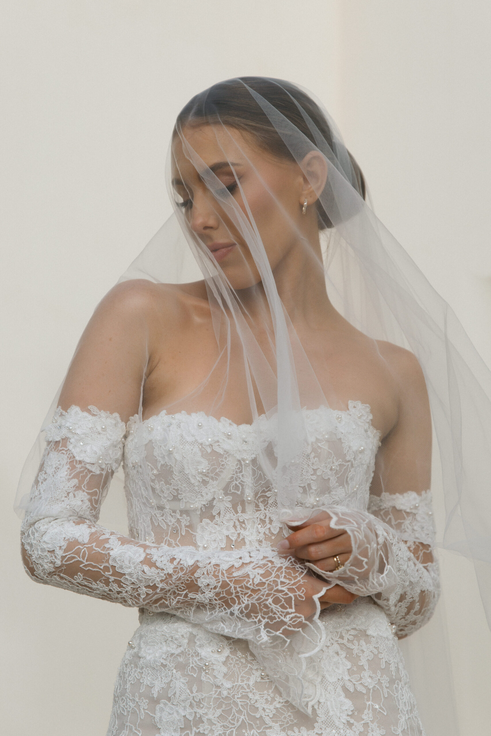 Bride in a lace off-the-shoulder gown with a sheer veil during her luxury destination wedding in Mallorca.