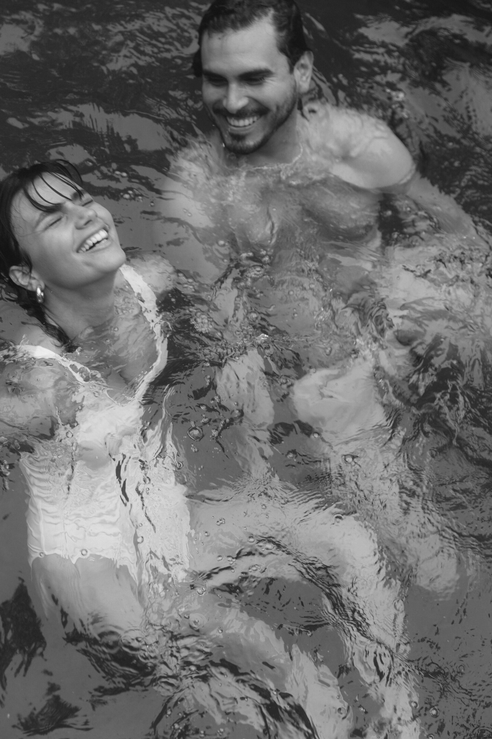 Couple laughing and enjoying candid moments in the pool at Le Chacuel Florida, captured in an editorial-style couples session.